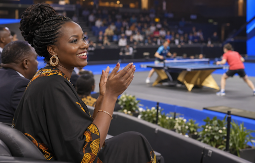 Woman clapping at a table tennis match from the VIP stands.